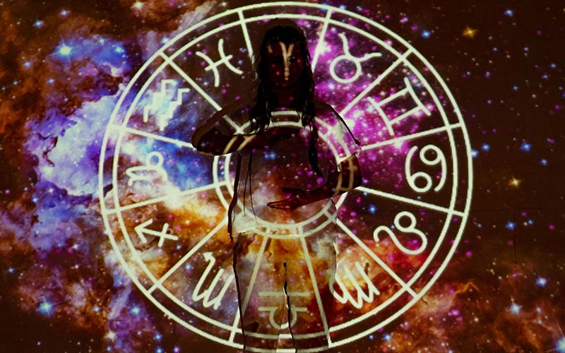 Imatge d'una persona en una nebulosa i amb símbols d'astrologia